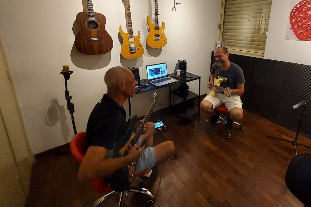 Professor e aluno tocando guitarra.