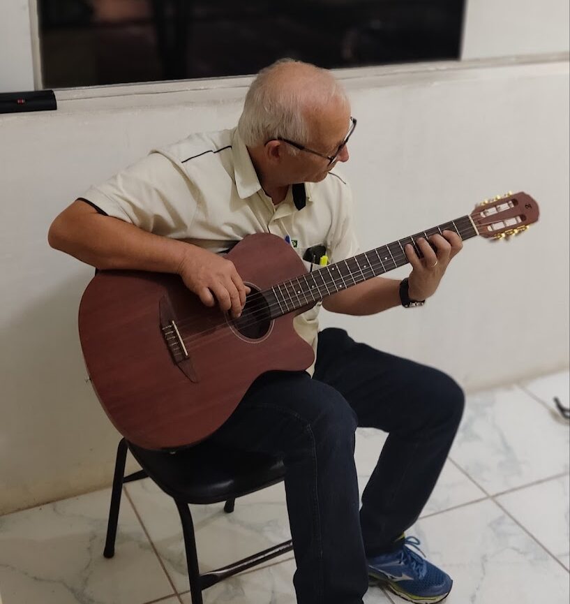 Idoso tocando violão.