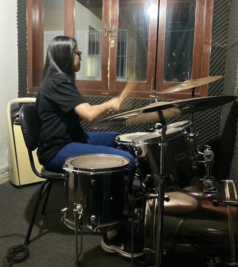 Mulher trocando bateria em sala acústica.